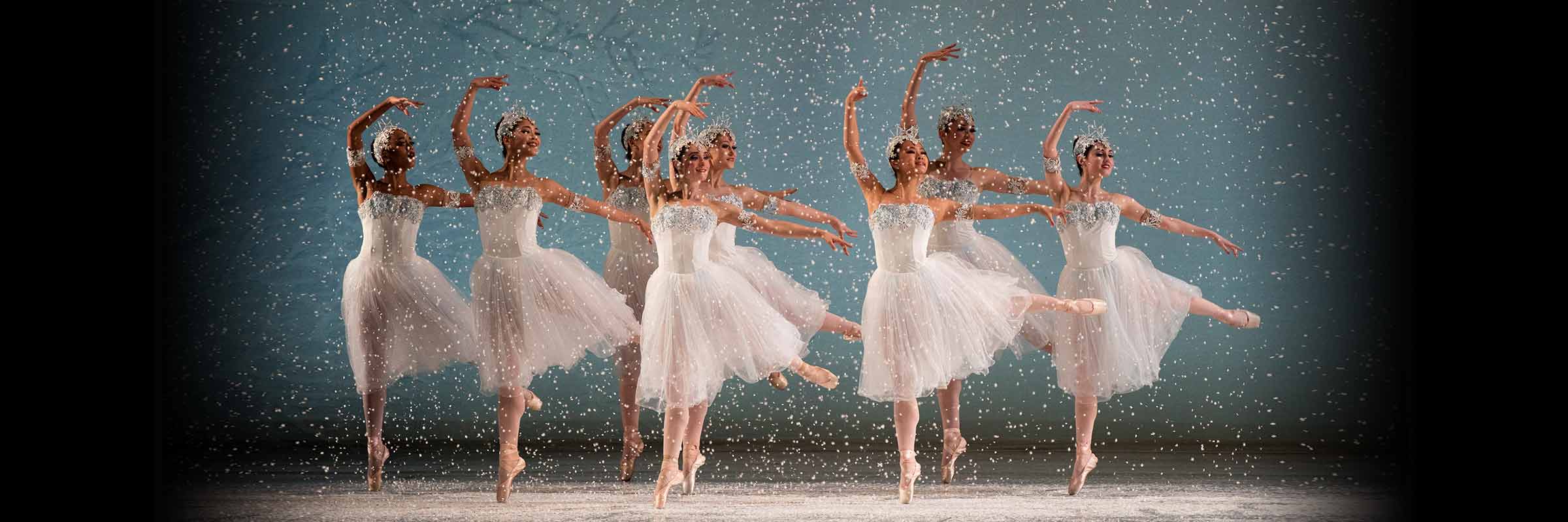 Snow falls as eight Snowflakes jump right, looking left, right legs down, left legs and arms out, right arms curved overhead