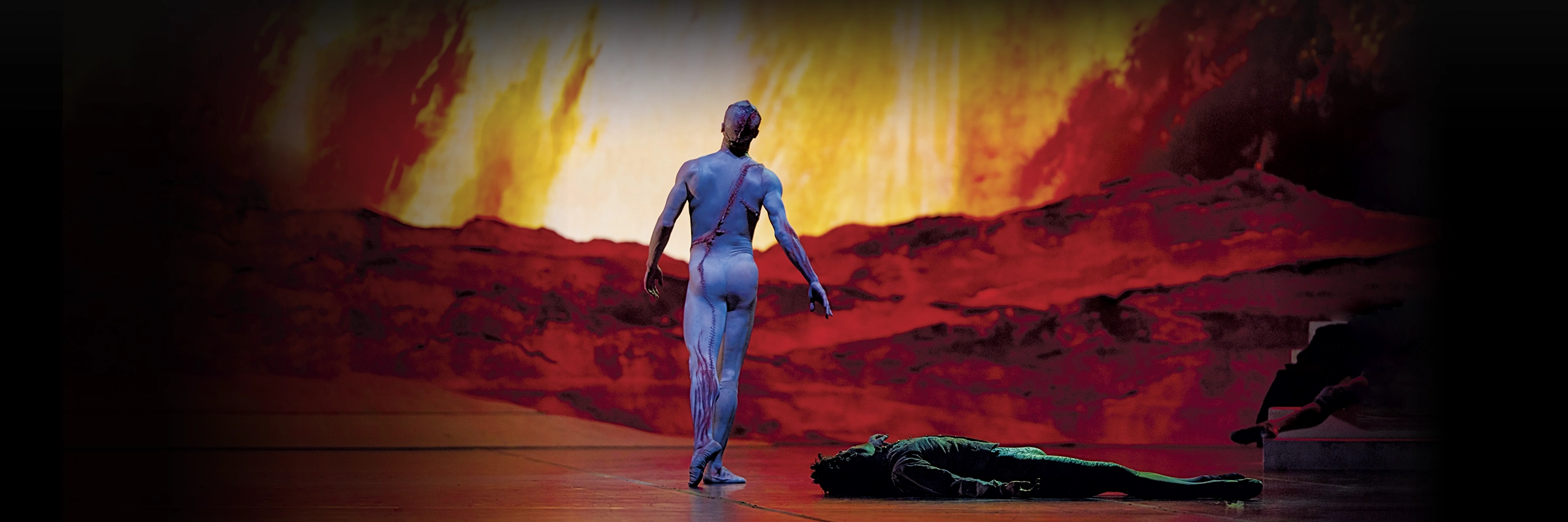Frankenstein's monster walking away into the background with a man lying on the ground in the foreground